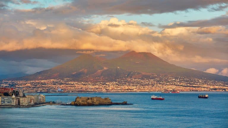 Mount Vesuvius seen from afar rising up above the surrounding cities