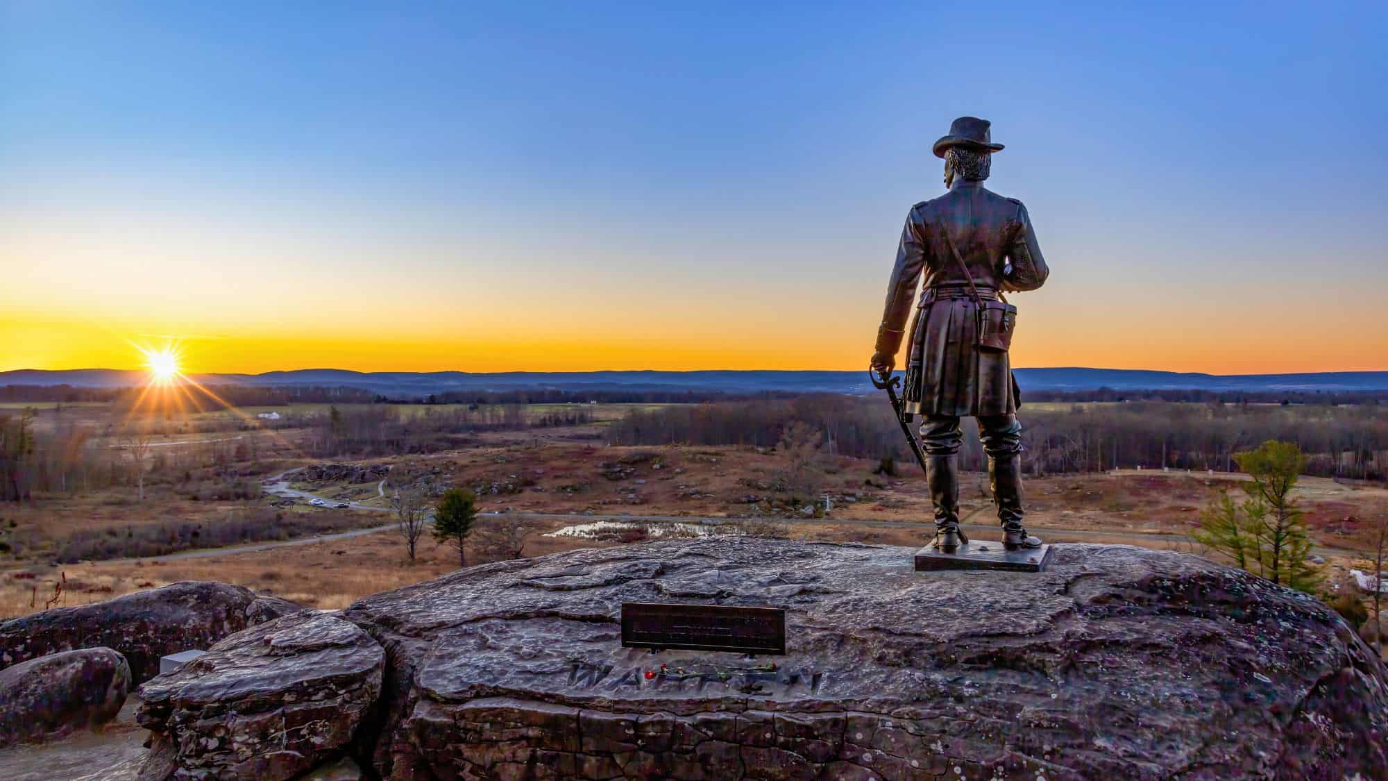 Gettysburg, Pennsylvania, USA - Nov 26, 2024: A breathtaking sunset over Gettysburg Battlefield from Little Round Top with the statue of General Warren.