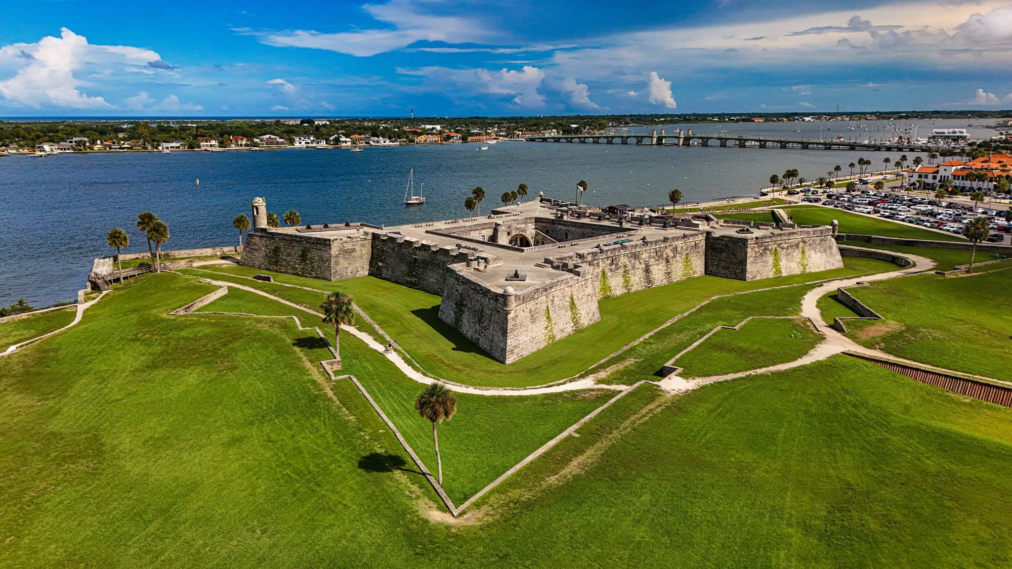 Aerial view of Castillo de San Marcos National Monument, a historic stone fort in St. Augustine, Florida, with surrounding green lawns and Matanzas Bay in the background.