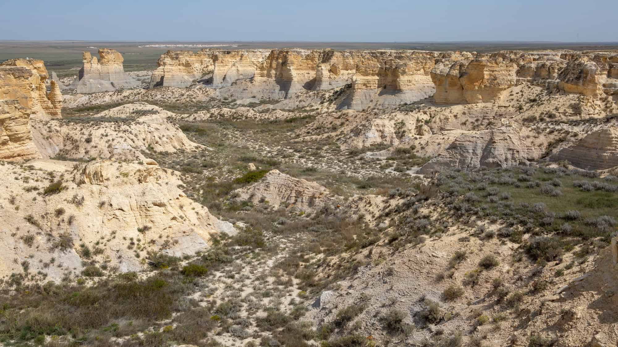 An expansive view of the Kansas badlands with rugged terrain and sparse vegetation.