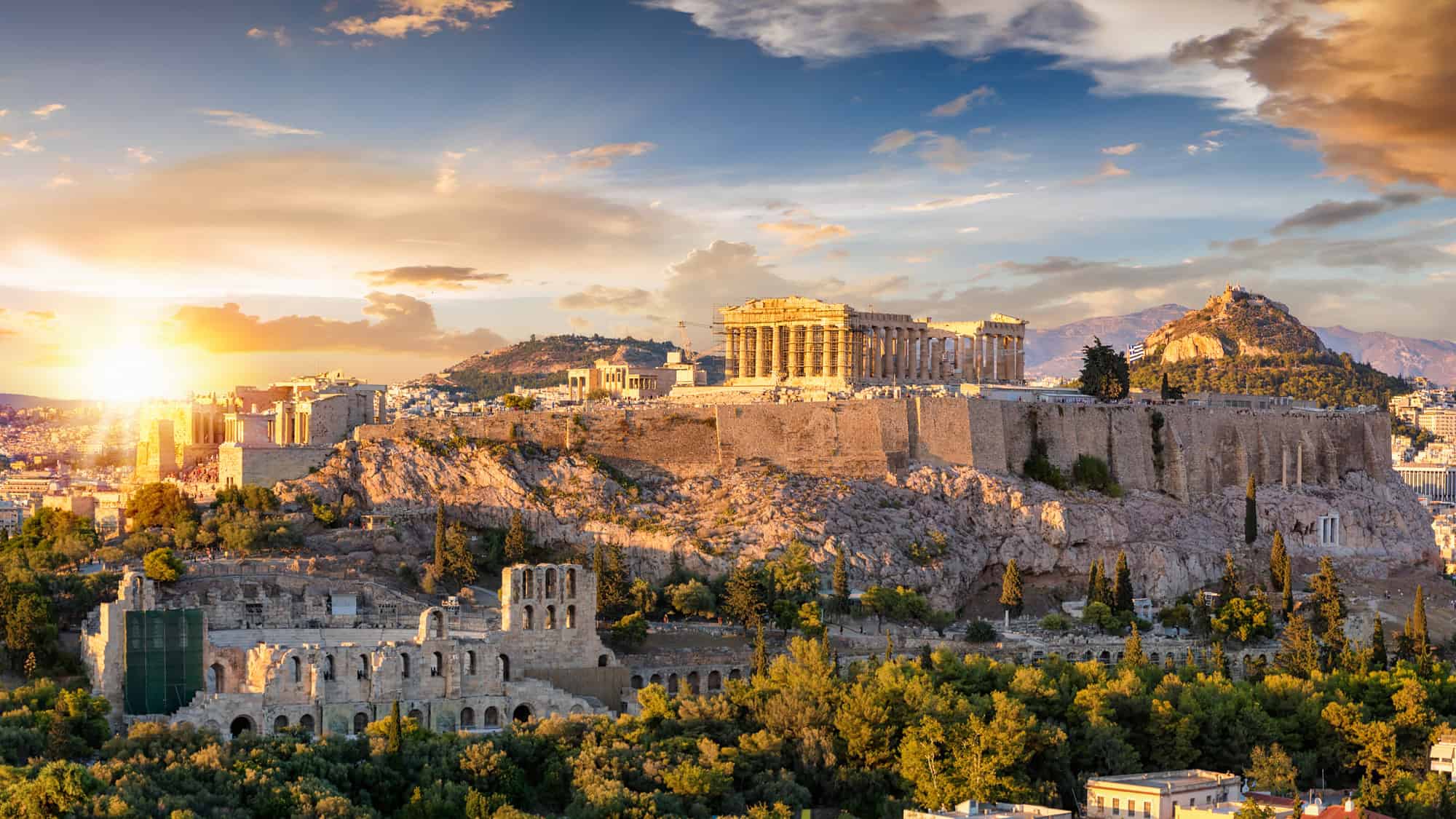 The Parthenon crowns the Acropolis in Athens, glowing in the golden light of sunset.